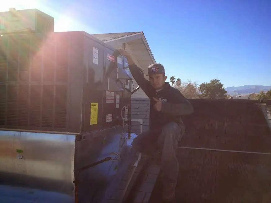 HVAC technician performing Heat Pump Repair on a rooftop unit in Vernal